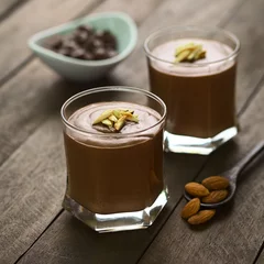  French dessert called Mousse au Chocolat, made of melted chocolate, egg, cream and sugar, served in glasses (Selective Focus, Focus on the middle of the almond pieces on the first dessert) © Ildi