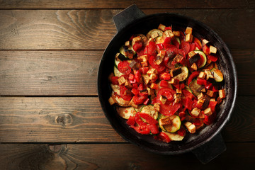 Tasty vegetarian ratatouille made of eggplants, squash, tomatoes and onions in black cast iron pan,...