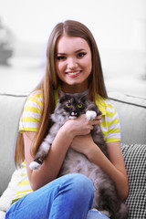 Beautiful young woman with cat at home