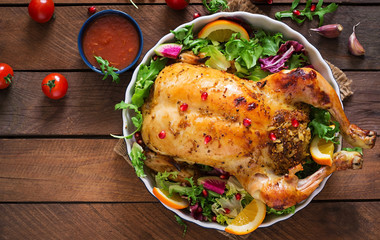 Baked chicken stuffed with rice for Christmas dinner on a festive table - obrazy, fototapety, plakaty