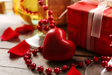 Setting of a bottle of wine, a gift in the box and other decoration, on wooden background