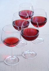 Glasses of red wine on table on bright background