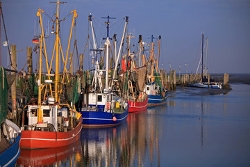Dorum hafen mit bunten roten und blauen Fischerbooten bei sonnigem, windstillem Wetter	