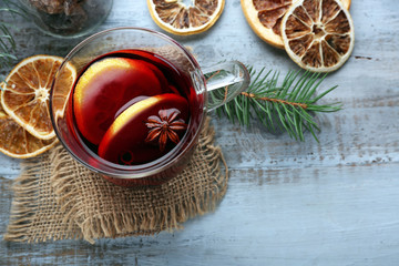 Tasty mulled wine and spices, on blue wooden background, close-up