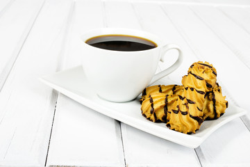 cup of coffee and delicious cakes on a white background