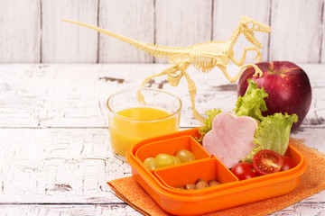 Tasty sandwich, lettuce and tomatoes in a lunch box. Back to school concept. Selective focus