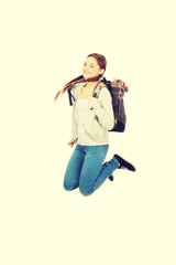 Teen woman jumping with backpack.