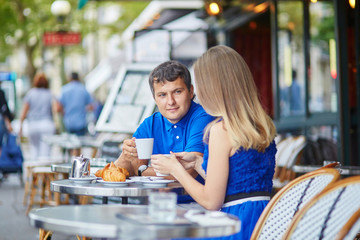 Beautiful young dating couple in Parisian cafe