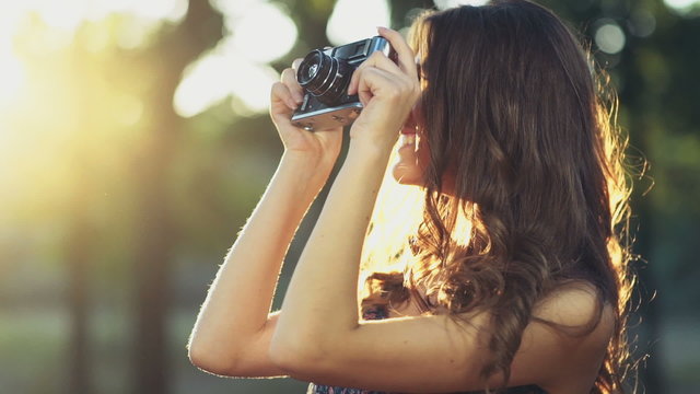 young female takes pictures with an old camera slow motion