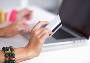 Young woman sitting with laptop  and holding  credit cart 