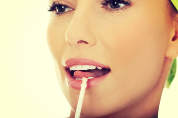 Beautiful woman applying lipstick.