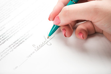Obraz na płótnie Canvas female hand signing a contract.