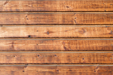 Naklejka premium Larch wooden planks on the building facade covered with preventive impregnation