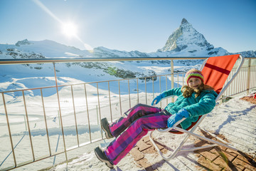 Girl with view of Matterhorn on a clear sunny day - Zermatt, Switzerland, winter vacation