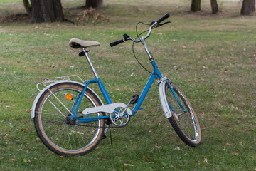 Fototapeta na wymiar Charming blue and white Polish city bike made in 1992. The eco-friendly lifestyle.