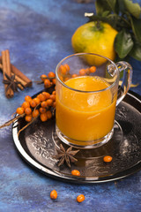 Hot high-vitamin beverage with tangerine, sea-buckthorn and spices. Selective focus