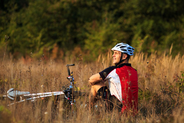 Fototapeta premium cyclist with bike relax in the sunny autumn park