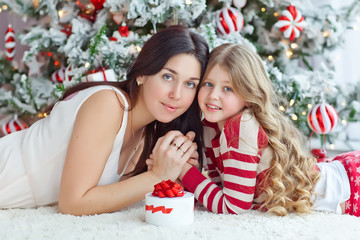 mother with daughter near christmas tree 