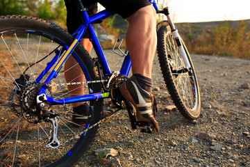 Fototapeta premium Detail of cyclist man feet riding mountain bike on outdoor