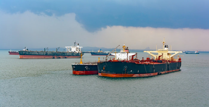 Loading anchored oil supertanker via a ship-to-ship oil transfer