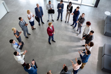 Business team with leader in centre of circle.