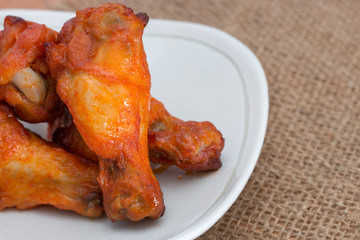Chicken wings in dish on brown sack.
