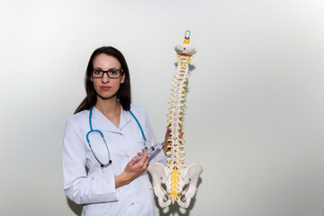 Young doctor holding a syringe and explain about epidural and back pain  