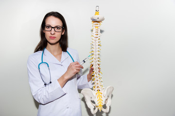 Young doctor holding a syringe and explain about epidural and back pain    