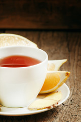 Ginger-lemon hot black tea with honey in a white porcelain dish,