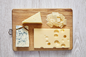 Fototapeta na wymiar four cheeses on white wooden table and chopping board