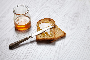 Dried pan topped with honey on white table with antique knife