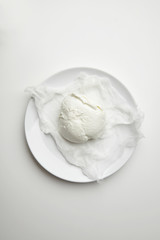 Fresh buffalo mozzarella isolated on white plate top view