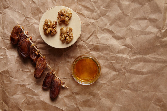 Dried datils, walnut and honey on craft brown paper top view