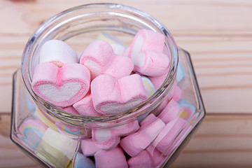 Marshmallows in jar on wooden table