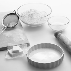 Sweet pastry making ingredients and utensils on a kitchen worktop.