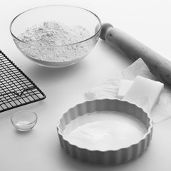 Pastry making ingredients and utensils on a kitchen worktop.