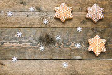 Gingerbread cookies on wooden background with snowflakes with space for your text
