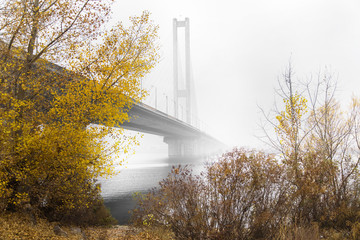 bridge over the river in the autumn fog