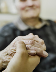 Altenpflegerin hält Hand einer Seniorin