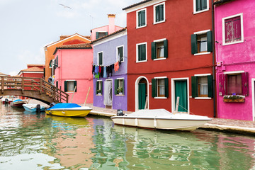 Fototapeta na wymiar Multi-colored walls of houses and motor boat on Burano's island, Venice