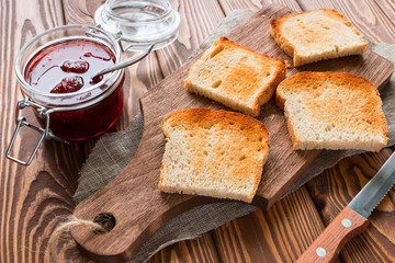 delicious toast on a cutting board next to a jar of jam
