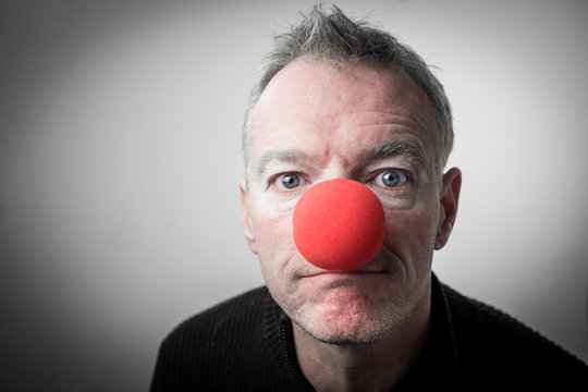 Personne avec un nez de clown qui fixe l'objectif