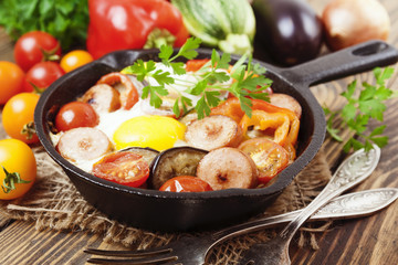 Fried eggs with vegetables and sausage