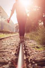 Young woman walking on railway tracks
