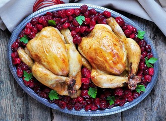 Baked chicken with cranberries on a wooden background 