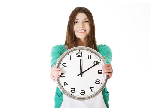 Happy woman holding office clock