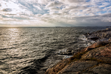 View over ocean just before sunset with a cloudy sky