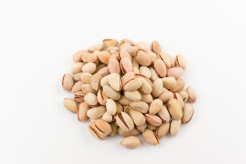 hill of pistachios in a shell lies on a white background