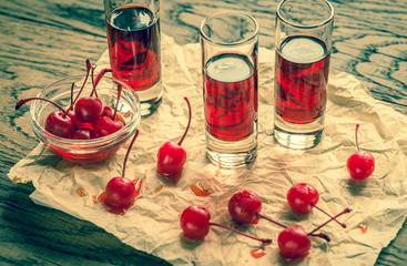 Glasses of cherry brandy with cocktail cherries