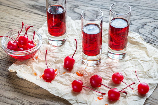 Glasses Of Cherry Brandy With Cocktail Cherries